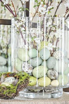 a vase filled with eggs and flowers on top of a table