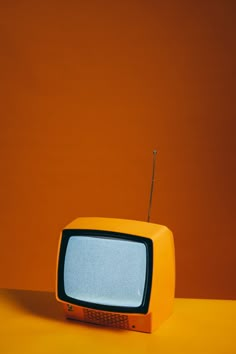 an old television sitting on top of a yellow table