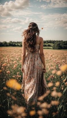 a woman walking through a field with flowers in her hair