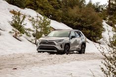 a silver toyota rav driving down a snow covered road