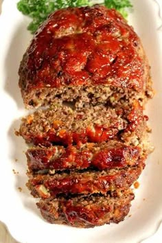 meatloaf with sauce and parsley on a white plate, ready to be eaten