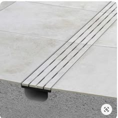 a concrete bench sitting on top of a cement floor next to a sidewalk with metal bars