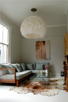 a living room filled with furniture and a large white ball hanging over the top of it