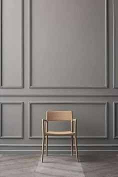 a chair sitting in front of a wall with gray paneling on the walls and floor