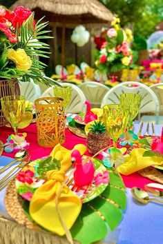 the table is set with colorful plates and place settings for an outdoor dinner or party