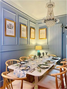 the dining room table is set with place settings for six people, and there are pictures on the wall behind it