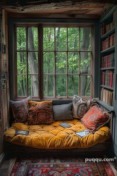 a window seat with bookshelves and pillows on it in front of a bookcase