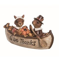 two figurines are sitting in a boat with the words give thanks