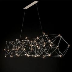 a light fixture with lights hanging from it's sides and on the ceiling, in front of a black background