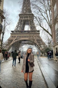 a woman standing in front of the eiffel tower