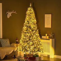 a christmas tree is lit up in the living room with presents on the floor and gifts under it