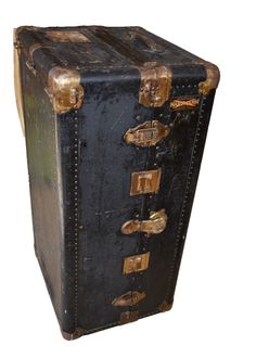 an old black trunk with gold handles and rivets on the sides, sitting upright