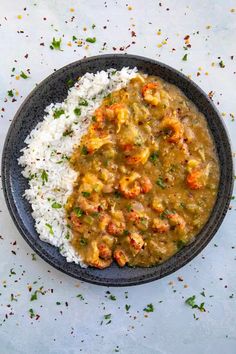 a black plate topped with rice and curry