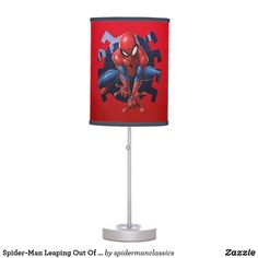 a lamp with a spiderman design on the side and a red shade over it