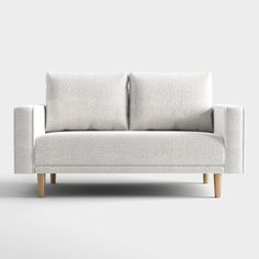 a white couch with two pillows sitting on it's back legs and one arm extended