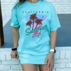 Trendy 90s aesthetic California Summer Days graphic printed on the front of the trendy, high quality Comfort Colors T-shirt. If you would like an oversized look like the pictures shown, please refer to the  measurement chart and size up a size or two, otherwise order your usual size. These shirts are relaxed fit so please keep that in mind as well! Thank you for supporting a small women owned business ~100% ring-spun cotton ~Medium fabric (6.1 oz/yd² (206.8 g/m ~Relaxed fit ~Sewn-in twill label Washing & Drying Instructions: Turn inside out. Wash with cold/warm water. Do not use bleach. Don't recommend tumble dry, hang dry or lay flat to dry. Green 90s Style T-shirt For Summer, Casual Printed Camp Shirt With Crew Neck, Spring Vsco Streetwear Tops, Retro Printed Summer T-shirt, 90s Style Summer Tops With Screen Print, 90s Style Screen Print Tops For Summer, Blue Graphic Print Summer Camp Shirt, Blue Graphic Print Camp Shirt For Summer, Green Letter Print T-shirt For Vacation