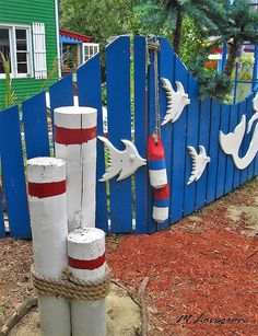 the fence is painted blue, white and red with two buoys tied to it