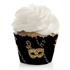 a black cupcake with white frosting and a gold mask on the top that is decorated with beads