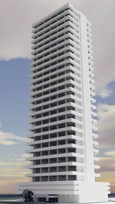 a tall white building sitting on top of a sandy beach next to the ocean in front of a cloudy blue sky