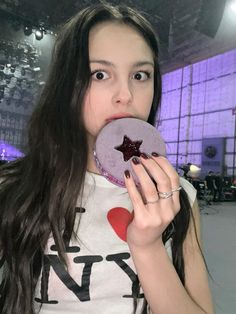 a woman holding up a purple plate with a star on it in front of her face