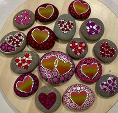 some rocks with hearts painted on them are arranged in a circle and placed on top of each other