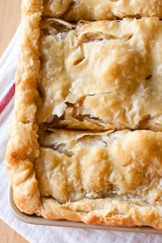 two pieces of pie sitting on top of a wooden table next to a white towel