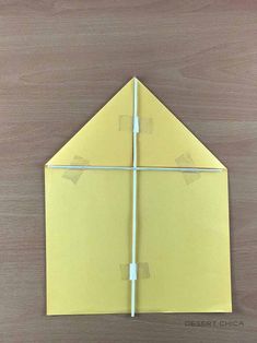 an origami envelope is folded in yellow paper