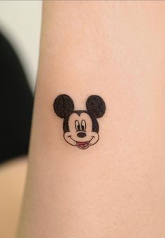 a close up of a person's wrist with a mickey mouse tattoo on it