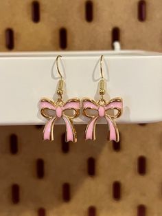 Dangly enamel earrings of pink ribbon bows Pink Enamel Jewelry For Party, Cute Pink Earrings For Gift, Cute Pink Earrings For Gifts, Butterfly Knot Drop Earrings For Gift, Pink Party Jewelry With Butterfly Knot, Cute Pink Jewelry With Matching Earrings, Feminine Jewelry With Pink Bow As Gift, Party Enamel Earrings For Pierced Ears, Pink Enamel Party Jewelry