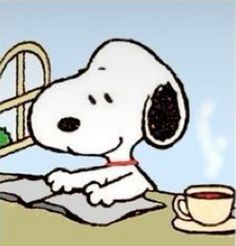 a snoopy dog sitting at a table with a cup of coffee