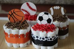 three rolls of toilet paper decorated with sports themed decorations on top of each roll are sitting on a wooden table