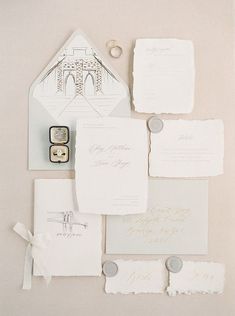 the wedding stationery is laid out on top of each other, including an envelope and ring