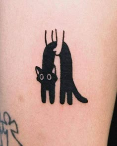 a black cat and kitten silhouette tattoo on the right thigh