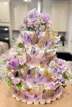 a multi layer cake decorated with butterflies and flowers