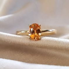 an orange ring sitting on top of a white cloth