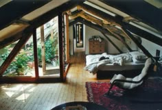 an attic bedroom with wooden floors and exposed ceilings