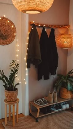 a room with some plants and lights on the wall next to a shoe rack filled with shoes