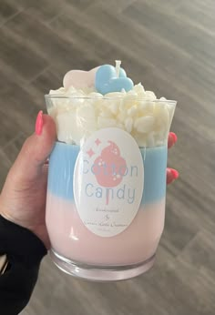 a person holding a cup filled with marshmallows and other things in it