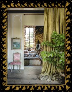 an image of a living room that is decorated with gold leafy curtains and furniture