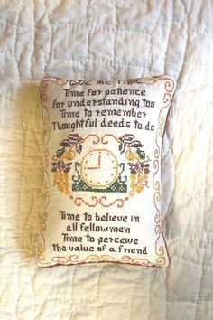 a cross stitch pillow with an old fashioned clock on it's front and back