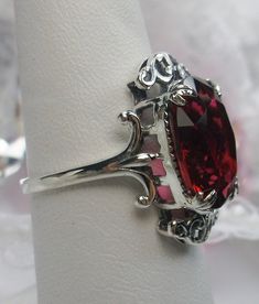 "Simulated Red Ruby Ring Vampire Design#84 MADE TO ORDER Inspired by Gothic & Renaissance era jewelry, I now offer this lovely Antique styles ring in sterling silver. This gorgeous ring is set with a flawless simulated/man-made red ruby gemstone. This flawless ruby red gem has excellent color and clarity. The full cut 5ct oval gem is 14mm (9/16th of an inch) Long by 10mm Wide (3/8th\"). The ring sits 7mm off the finger. The inside of the band is marked 925 for sterling. Notice the intricate Classic Red Ruby Ring, Oval Cabochon, Classic Red Ruby Ring With Oval Cabochon, Sterling Silver Ruby Ring With Vs Clarity, Heirloom Oval Jewelry For Valentine's Day, Classic Red Ruby Jewelry, Classic Oval Ruby Ring, Classic Red Jewelry With Lab-created Ruby, Red Lab-created Ruby Jewelry With Polished Finish, Red Polished Lab-created Ruby Jewelry