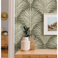 the wallpaper in this living room is designed to look like palm leaves, and has been