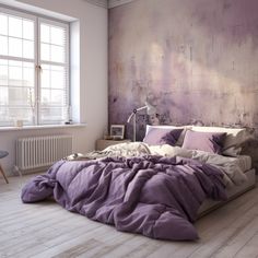 a large bed with purple sheets and pillows in a white room next to a window