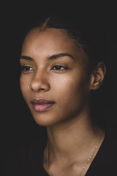 a woman wearing a necklace and nose piercing