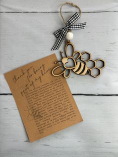 a wooden bee ornament next to a piece of paper