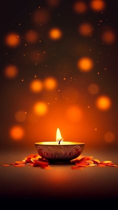 a lit candle sitting on top of a table next to some red and orange leaves