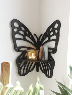 a butterfly shaped candle holder on a wall