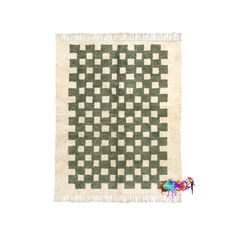 a green and white checkered rug with fringes on the bottom, in front of a