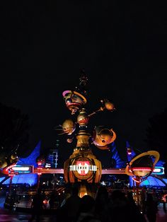 people are standing in front of a lit up lantern at night