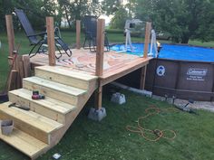 an above ground swimming pool with steps leading up to the deck and above ground hot tub